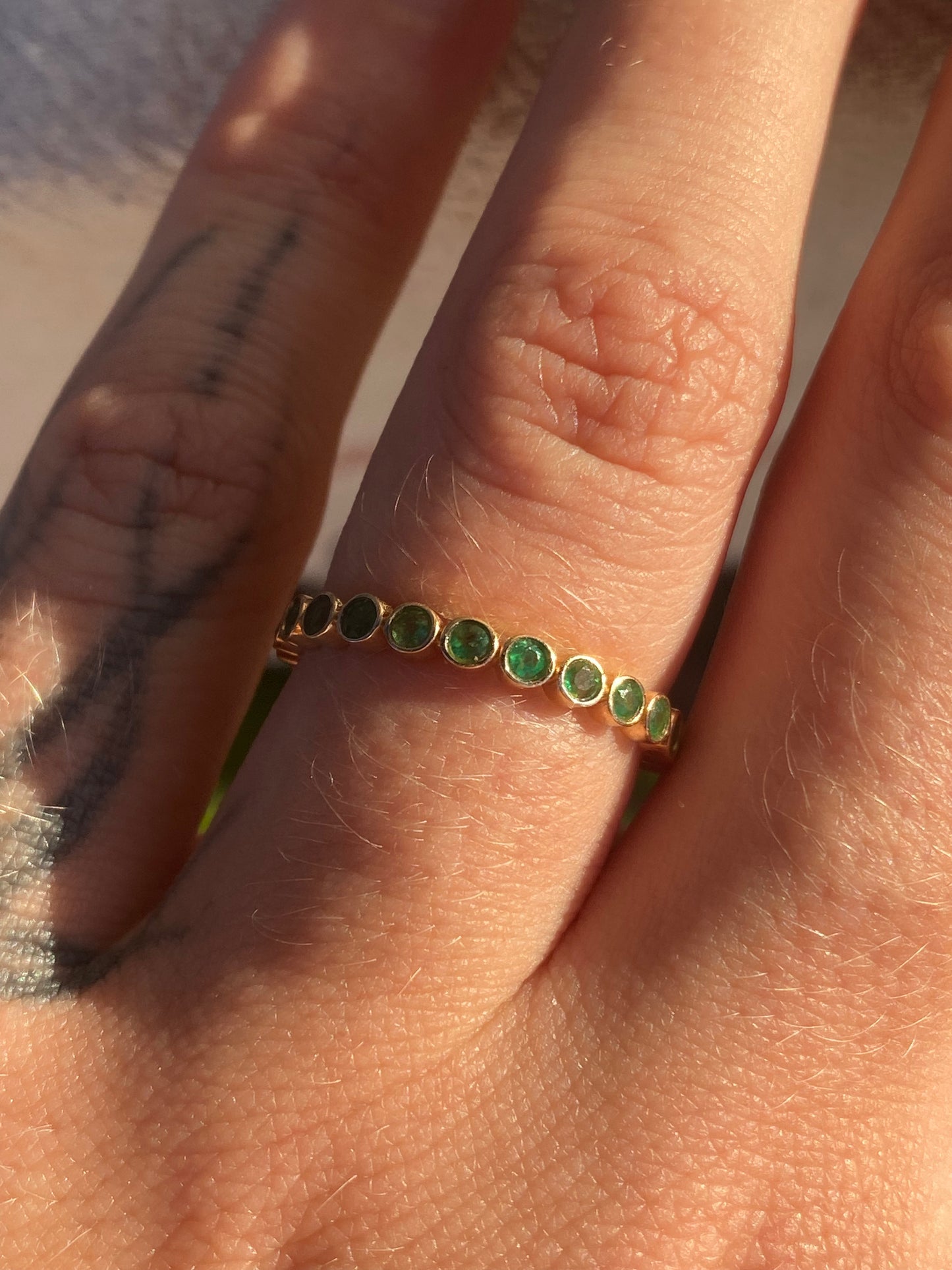 14kt .60ctw emerald bezel eternity band