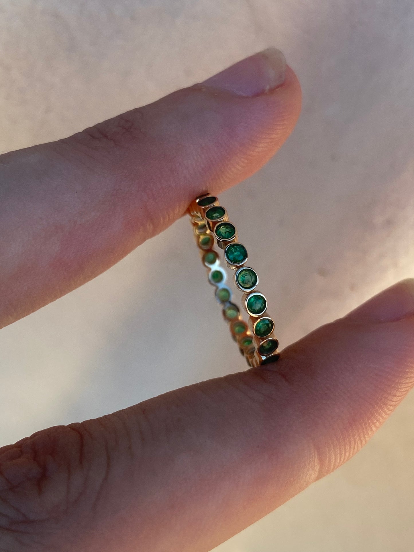 14kt .60ctw emerald bezel eternity band